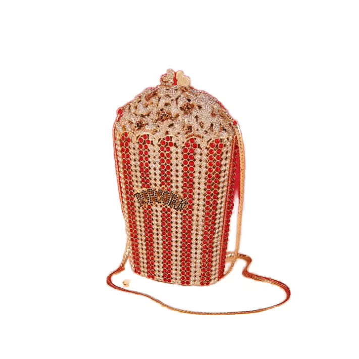 A beaded popcorn-shaped handbag with red and gold rhinestone stripes, a gold-tone 'Popcorn' logo on the front, and a matching shoulder strap, shown on a plain white background.